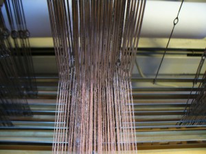 spraying among the heddles